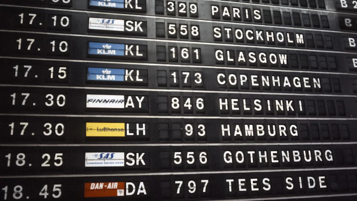 An airport departures board listing flights to Paris, Stockholm, Copenhagen and Helsinki
